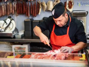 Male,Butcher,Boning,Fresh,Ham,In,A,Modern,Butcher,Shop