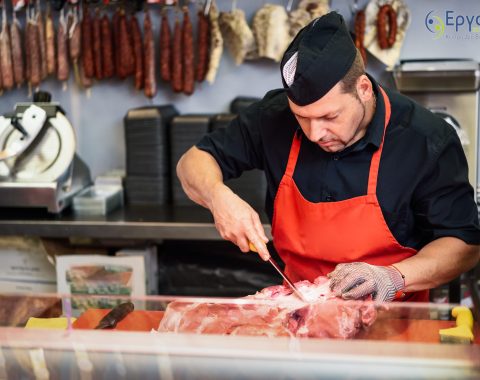 Male,Butcher,Boning,Fresh,Ham,In,A,Modern,Butcher,Shop